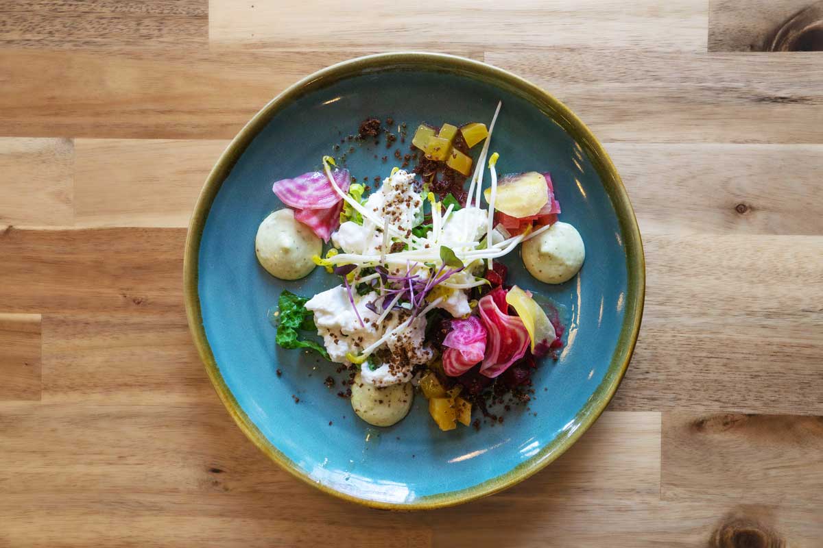 Angerichteter Teller auf einem Tisch mit vegetarischen Essen